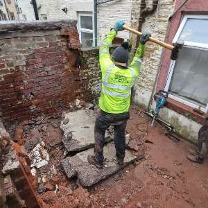 Worker breaking up concrete during a property rip out