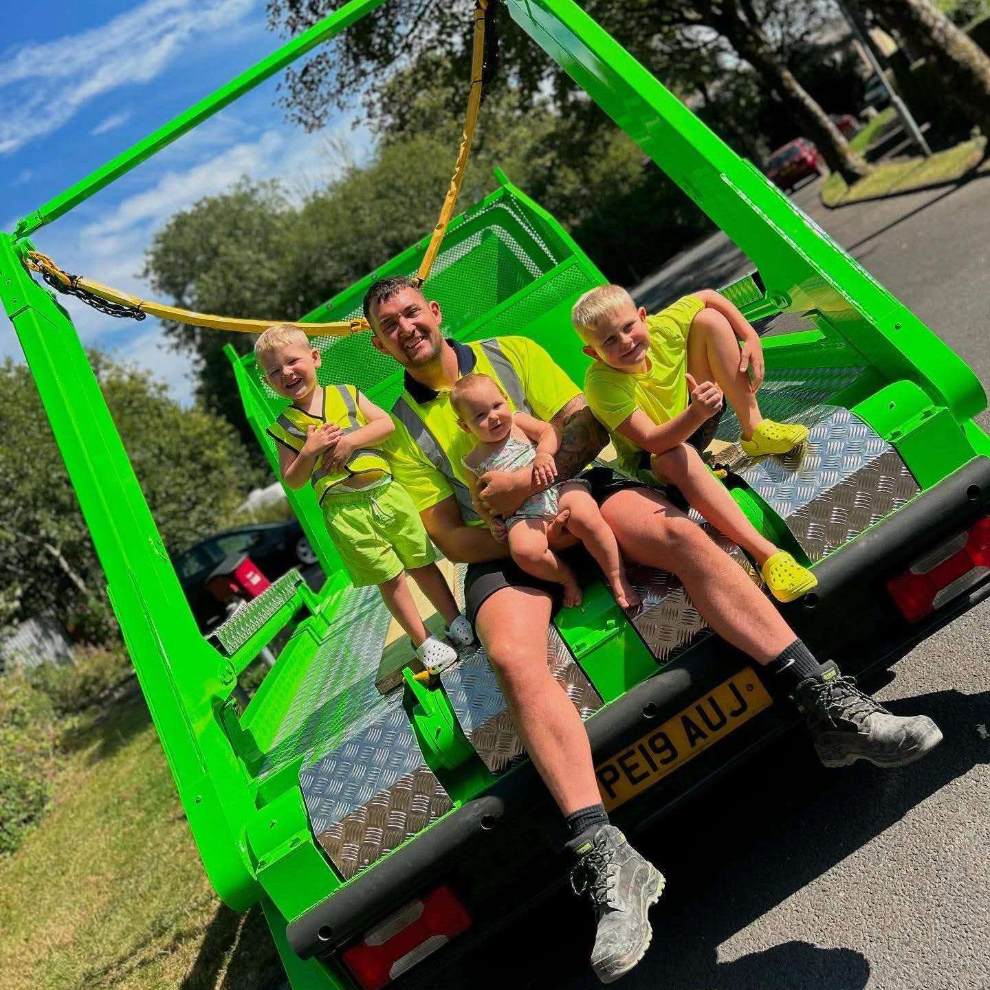 DR Waste owner and family sitting in a green skip